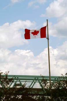 A Canadian Flag flying over a walking bridge