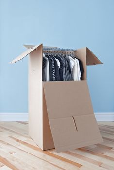 Wardrobe box with black and white clothing, prepared for transportation.