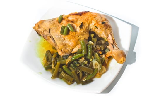 Fried chicken leg with french beans on white plate. Isolated.