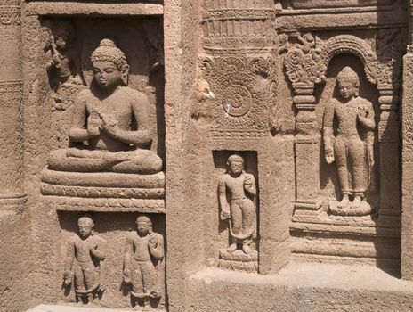 Religious figures carved out of the rock on the facade of an ancient Buddhist cave temple Ajanta Caves near Aurangabad India. 5th-6th Century AD