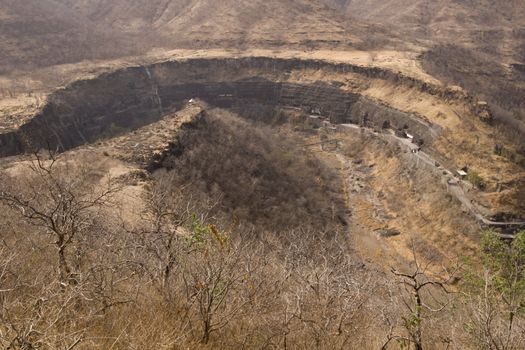 Horseshoe shaped river valley. Ancient rock temples and caves carved out of the cliff face. Ajanta Caves near Aurangabad, India. 1st Century BC to 6th Century AD.
