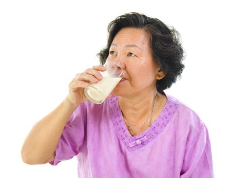 Asian senior woman drinking a glass of soy milk over white background