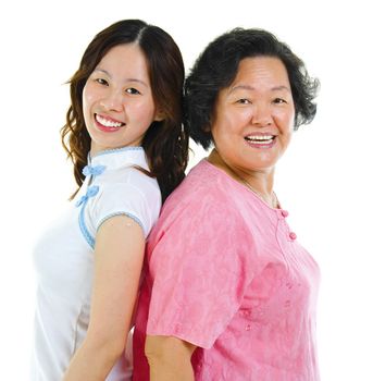 Portrait of two Asian women back to back, over white background