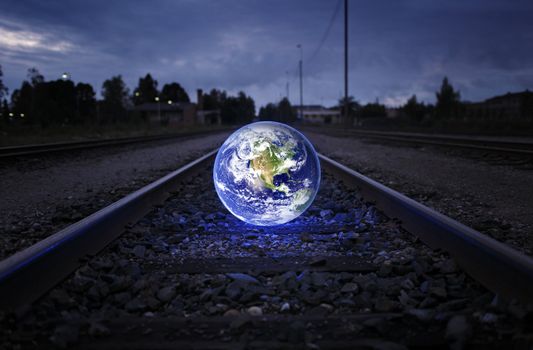 Glowing earth on an old railroad track. Earth image provided by NASA.