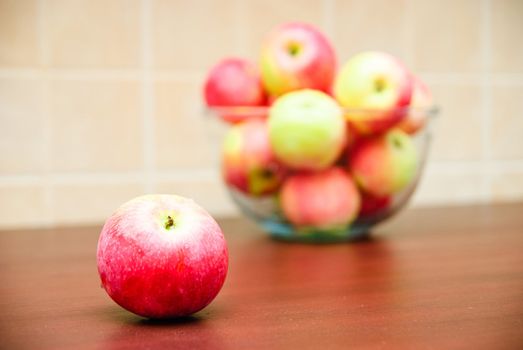 Juicy apple and blurred glass bowl filled with apples