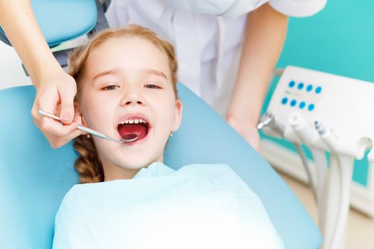 Little girl sitting in the dentists office