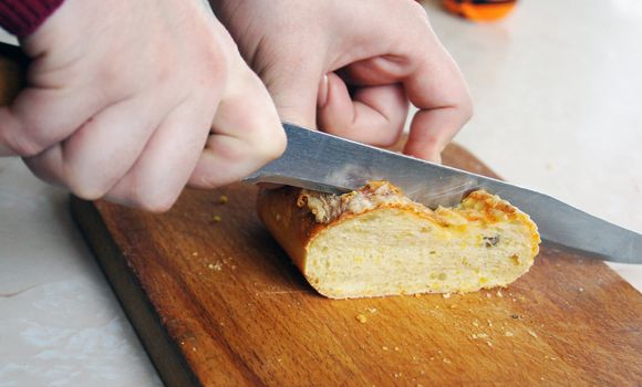 Hands cut the bread