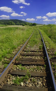 Old railway in the country with blue sky and clouds