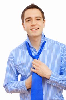 Young businessman at home preparing for a work and making his tie