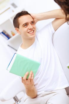 Young handsome man at home with a book