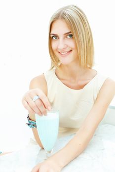 Young beautiful woman with a glass of drink sitting in a cafe