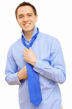 Young businessman at home preparing for a work and making his tie