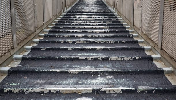 Old weathered steel and aluminum ships boarding ramp in diminishing perspective