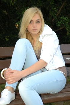 Young female model wears casual clothes. Sits with natural face expression, teenage girl cool and relaxed. 