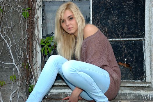 Young female model wears casual clothes. Sits near window with natural face expression, teenage girl cool and relaxed.