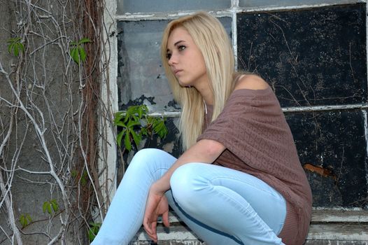 Young female model wears casual clothes. Sits near window with natural face expression, teenage girl cool and relaxed.