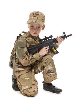 Young boy dressed like a soldier with rifle isolated on white