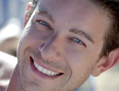 Head shot of blue eyed attractive male model smiling