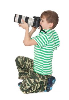 Boy holding a camera isolated on white