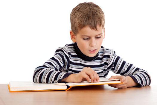 Cute schoolboy is reading a book isolated on a white background