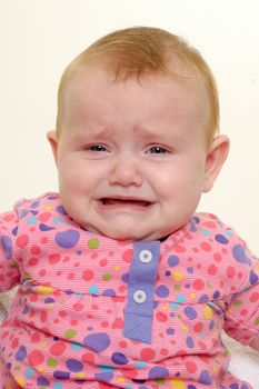 Sad baby is crying. Isolated on a white background.