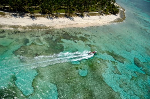 Speedboat and beach taken from above in helicopter