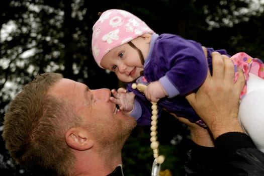 Happy father is lifting up his smiling baby
