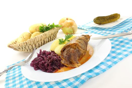 delicious stuffed Beef roulade with potatoes and red cabbage on a light background