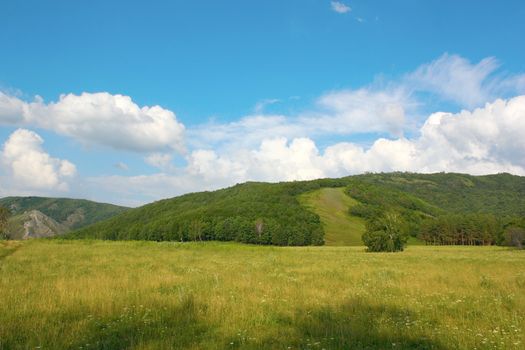 Summer landscape with mountains. Blue sky with clouds