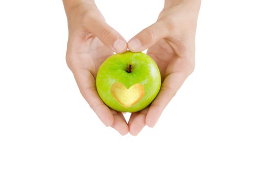 female hand and green apple with  heart shape 