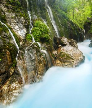 Beautiful alpine brook in the rocky canyon with many small waterfalls