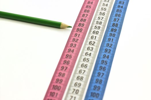 nice conceptual image with measure tapes and green pencil