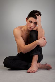 Healthy muscular young man. Isolated on grey background.