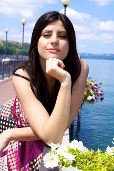 Young woman happy on a dock of a lake with beautiful flowers