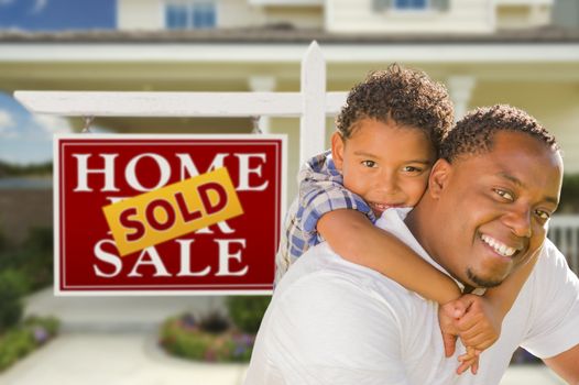 Happy Mixed Race Father and Son In Front of Sold Real Estate Sign and New House.