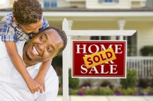 Happy Mixed Race Father and Son In Front of Sold Real Estate Sign and New House.