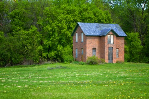 An abandoned brick farmhouse on the Midwest United States Prairie.
