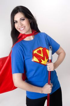 Woman wears a superhero style t-shirt and cape holding a broom