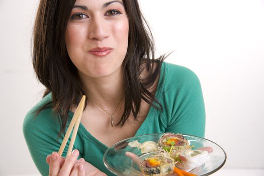 A brunette woman eats a Sushi Lunch