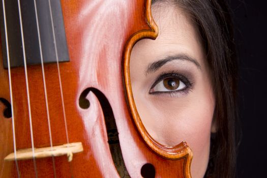 A Woman's Face with eye looking up Behind Violin