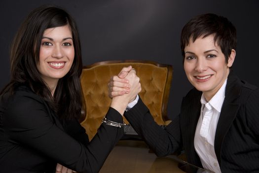 Two business partners have an arm wrestling match