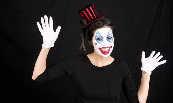 Woman clowning around against black