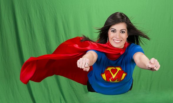 Beautiful woman plays super mom flying on green screen