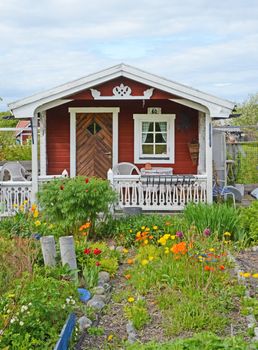 A small red cottage in a garden