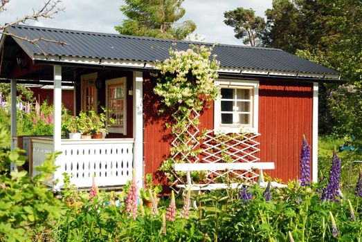 A small red cottage in a garden