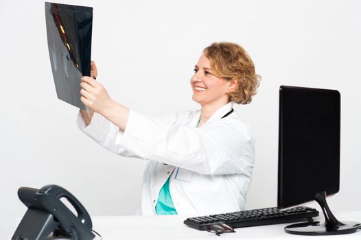 Smiling female surgeon in her chamber looking at patients x-ray report