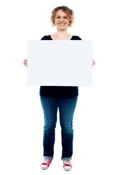 Female showing white blank advertising board, full length portrait
