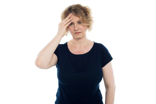 Aged woman having headache. Holding her head