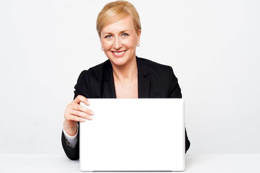 Secretary holding laptop flap, about to close. Isolated on white background