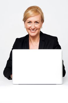 Aged corporate lady working on a laptop isolated against white background